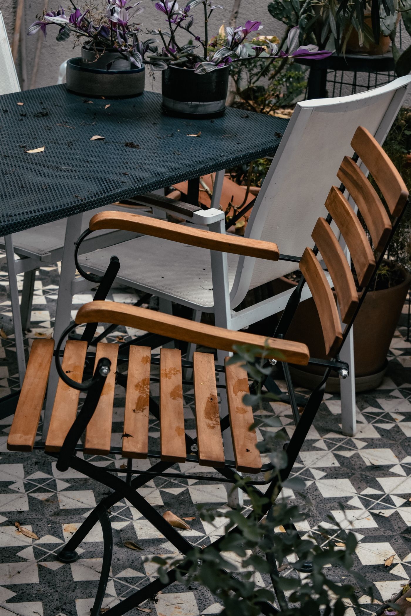 A folding wooden chair tucked beside a small balcony table.