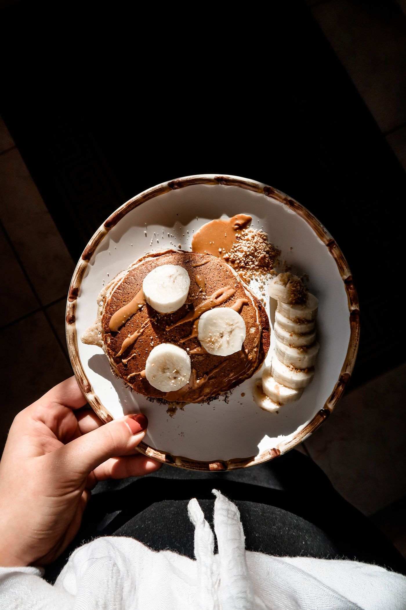 Small pancakes topped with banana slices on a breakfast plate.