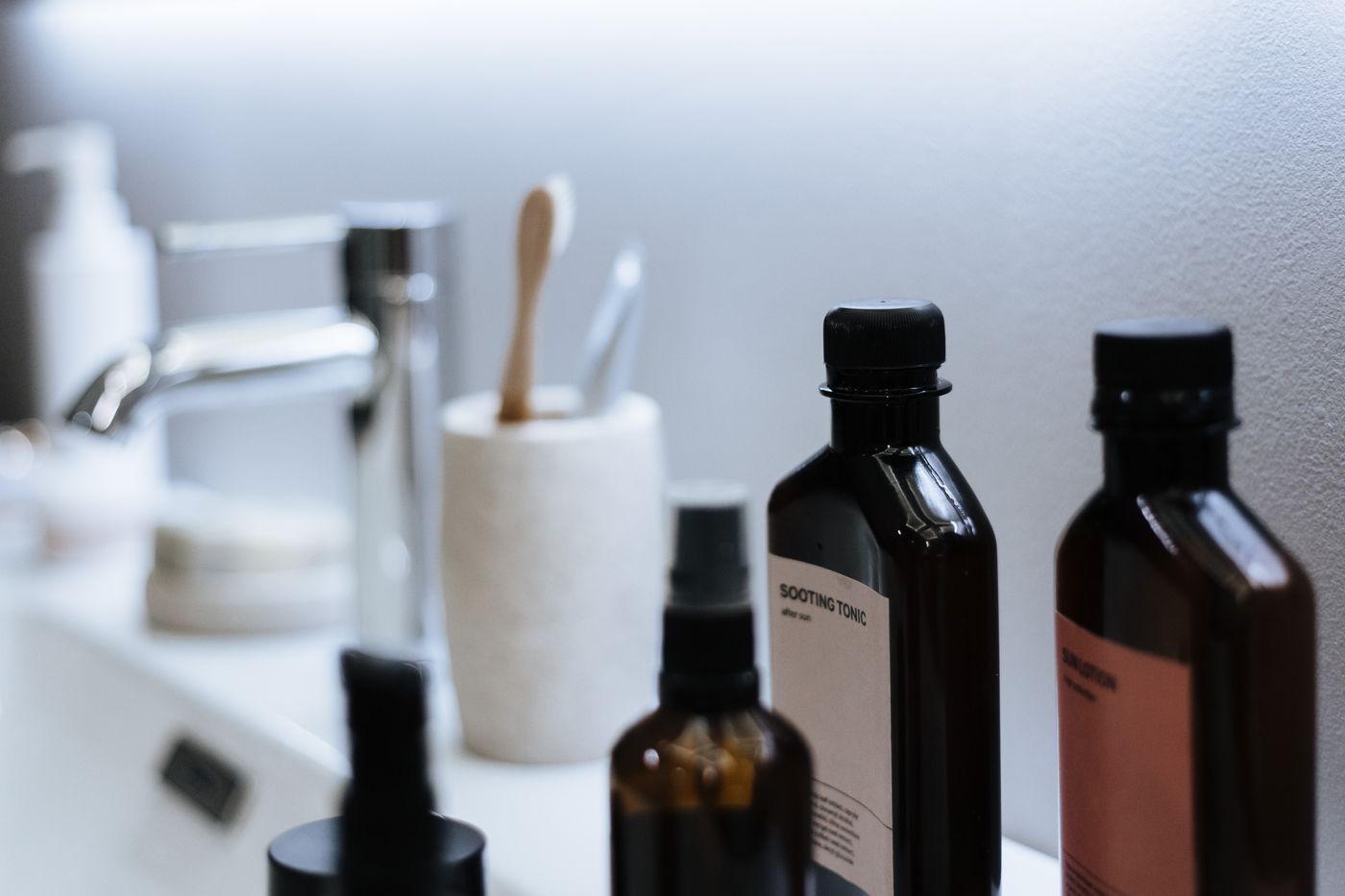 Everyday toiletries grouped on a bathroom counter beside the sink.