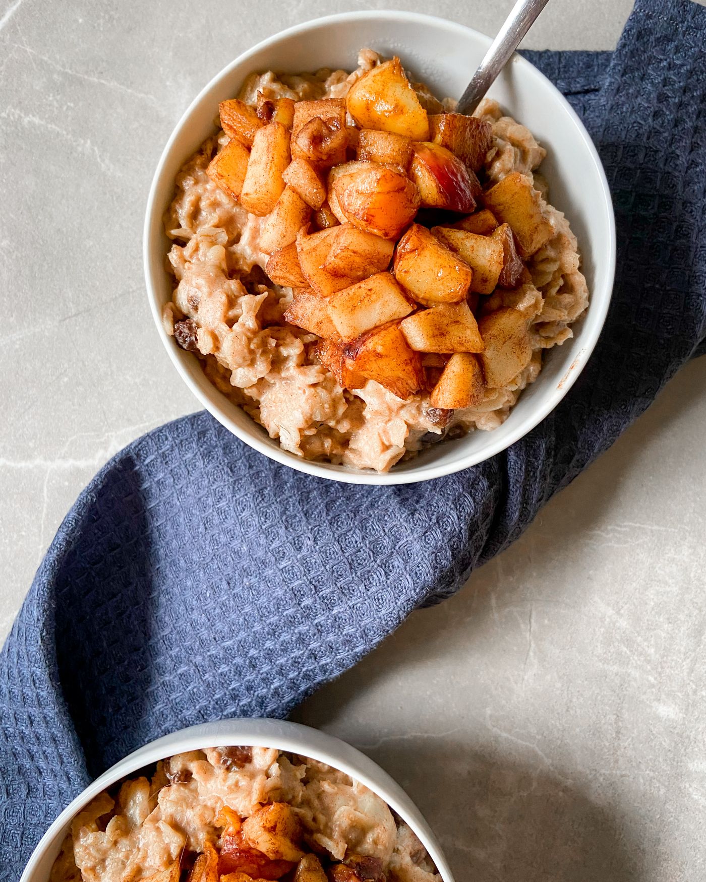 A bowl of porridge topped with warm cinnamon apples.
