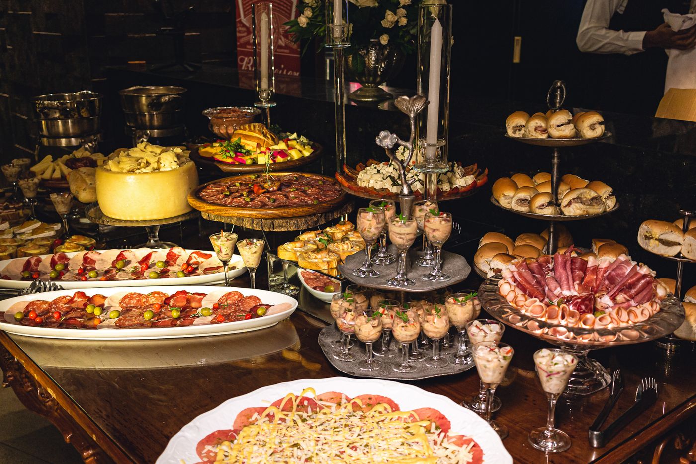 A buffet table arranged with platters and tiered serving stands.