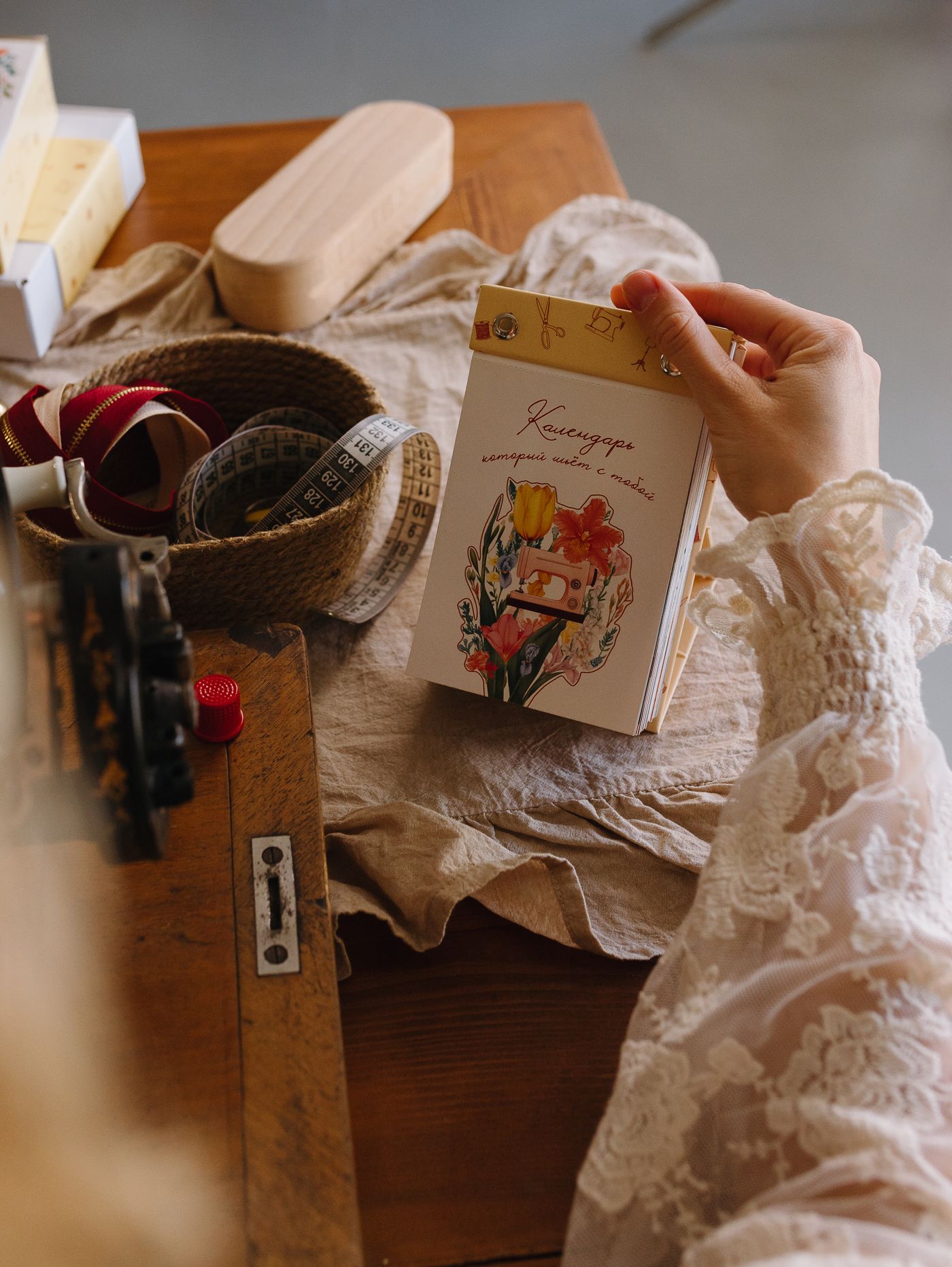 Craft materials, ribbon and a small basket arranged on a work table.