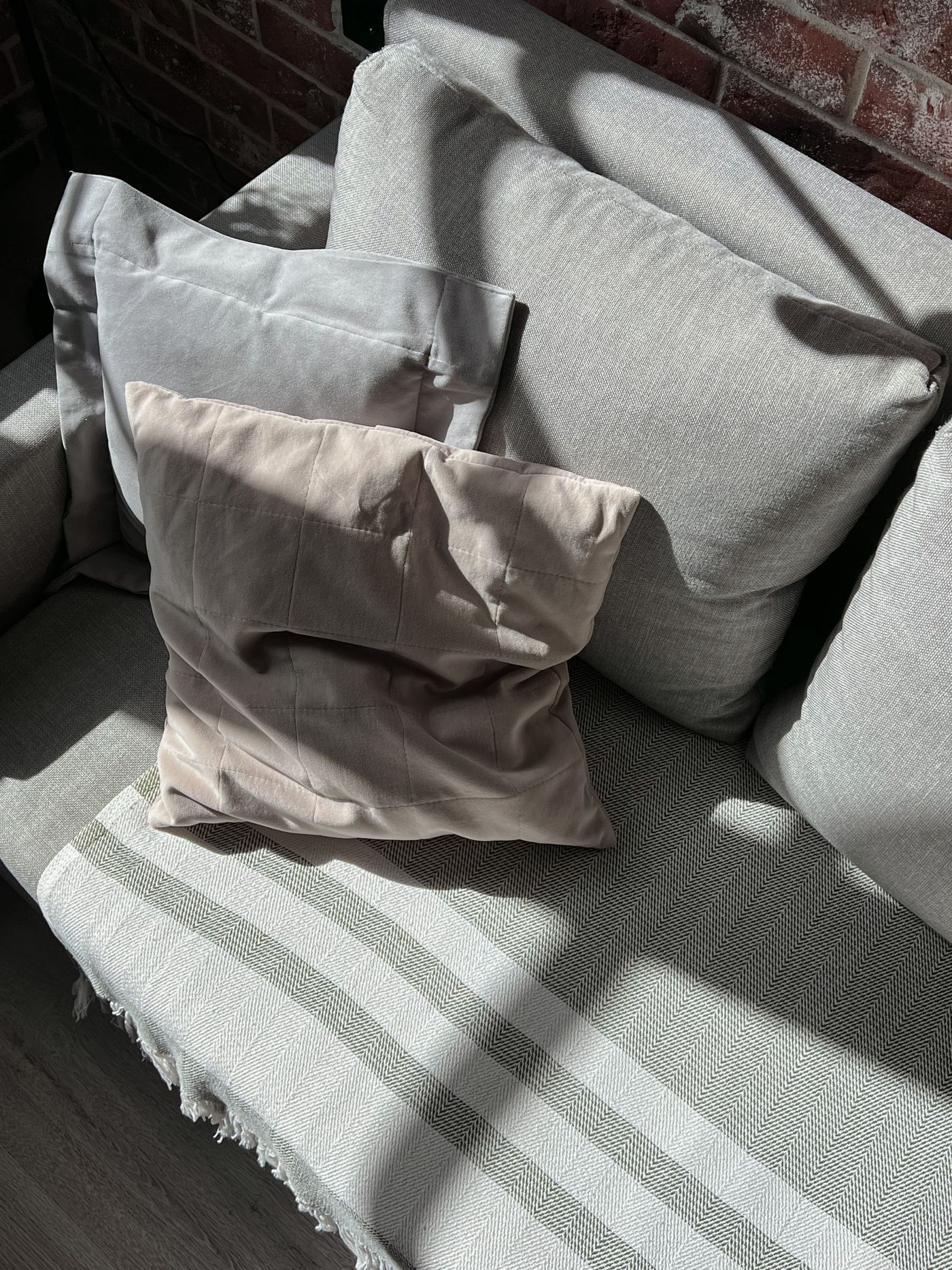 Neutral cushions with different textures on a sofa.