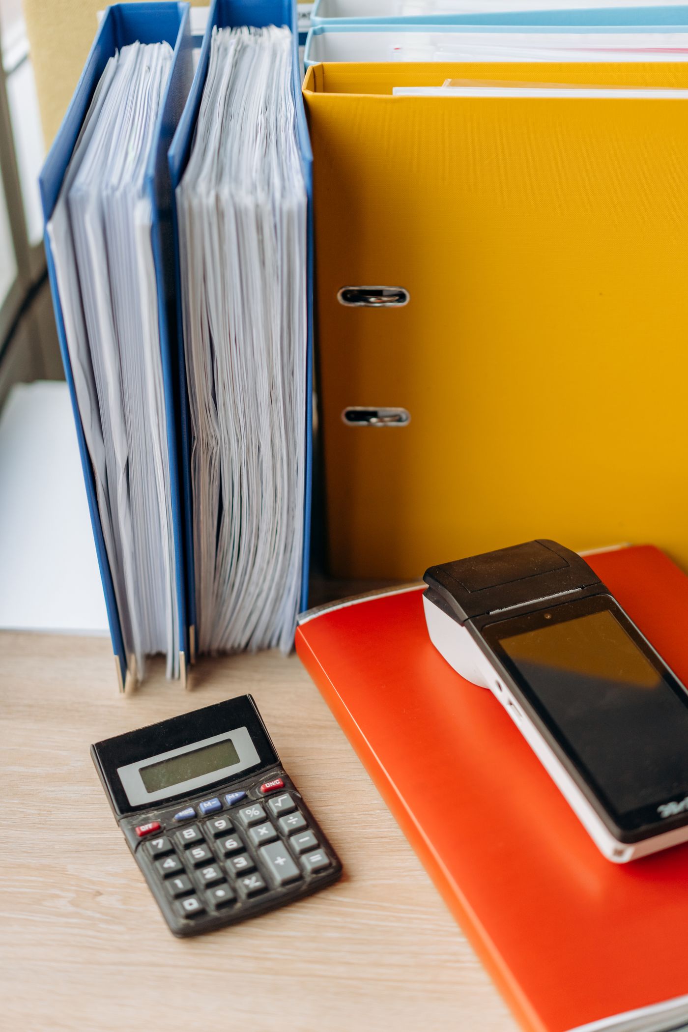 Upright files, folders and a calculator on a desk.