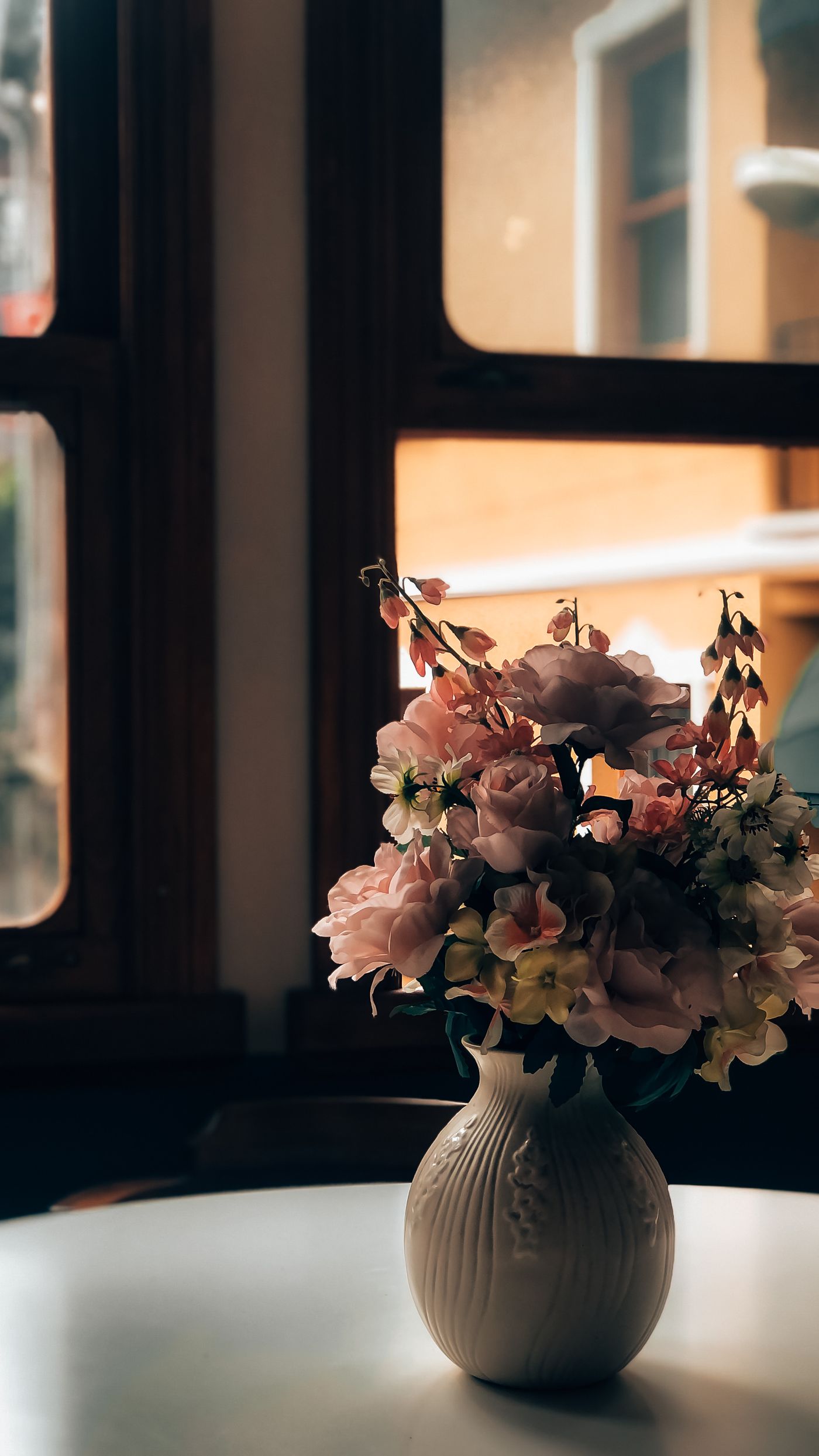 A bouquet of flowers in a ribbed vase on a table.