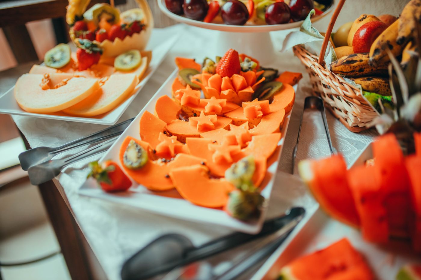 Slices of melon and other fruits arranged on serving platters.