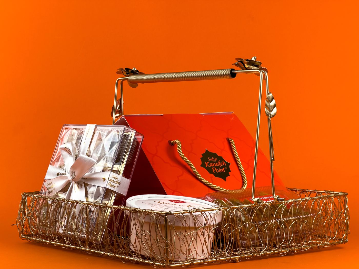 A gift basket arranged with wrapped treats and a ribbon.