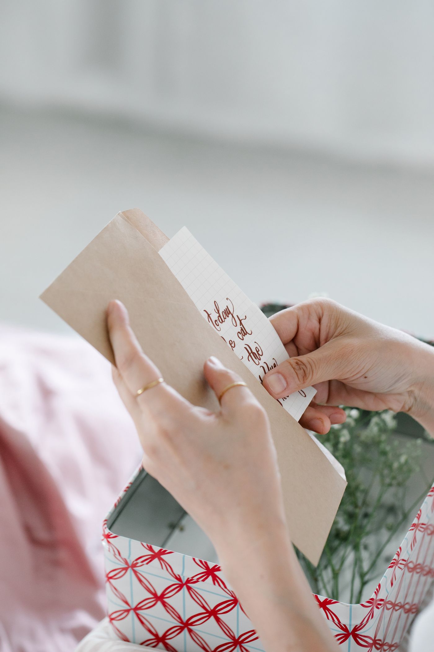 A person holding a small greeting card and an envelope.