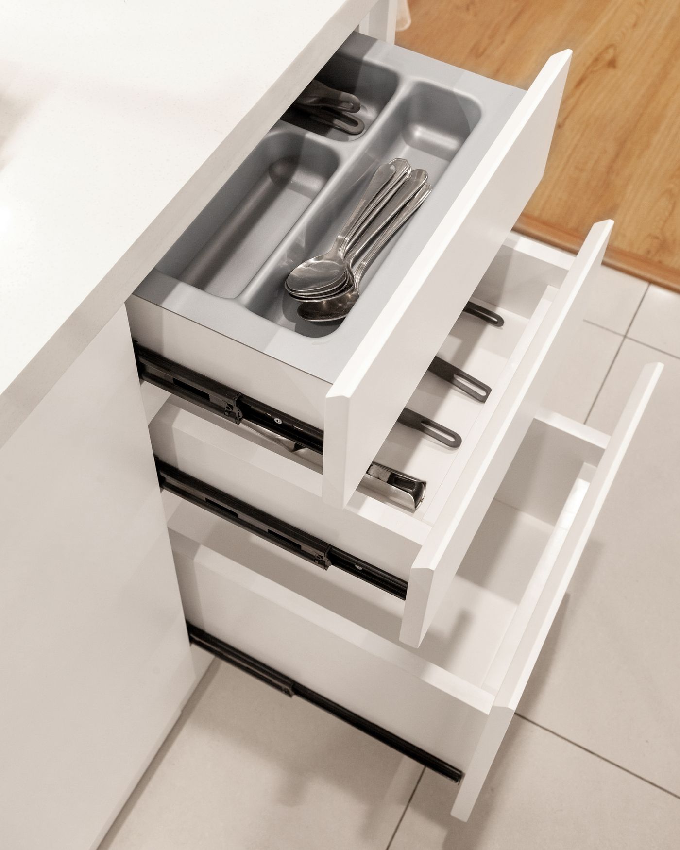 An open kitchen drawer with a divided utensil organiser.