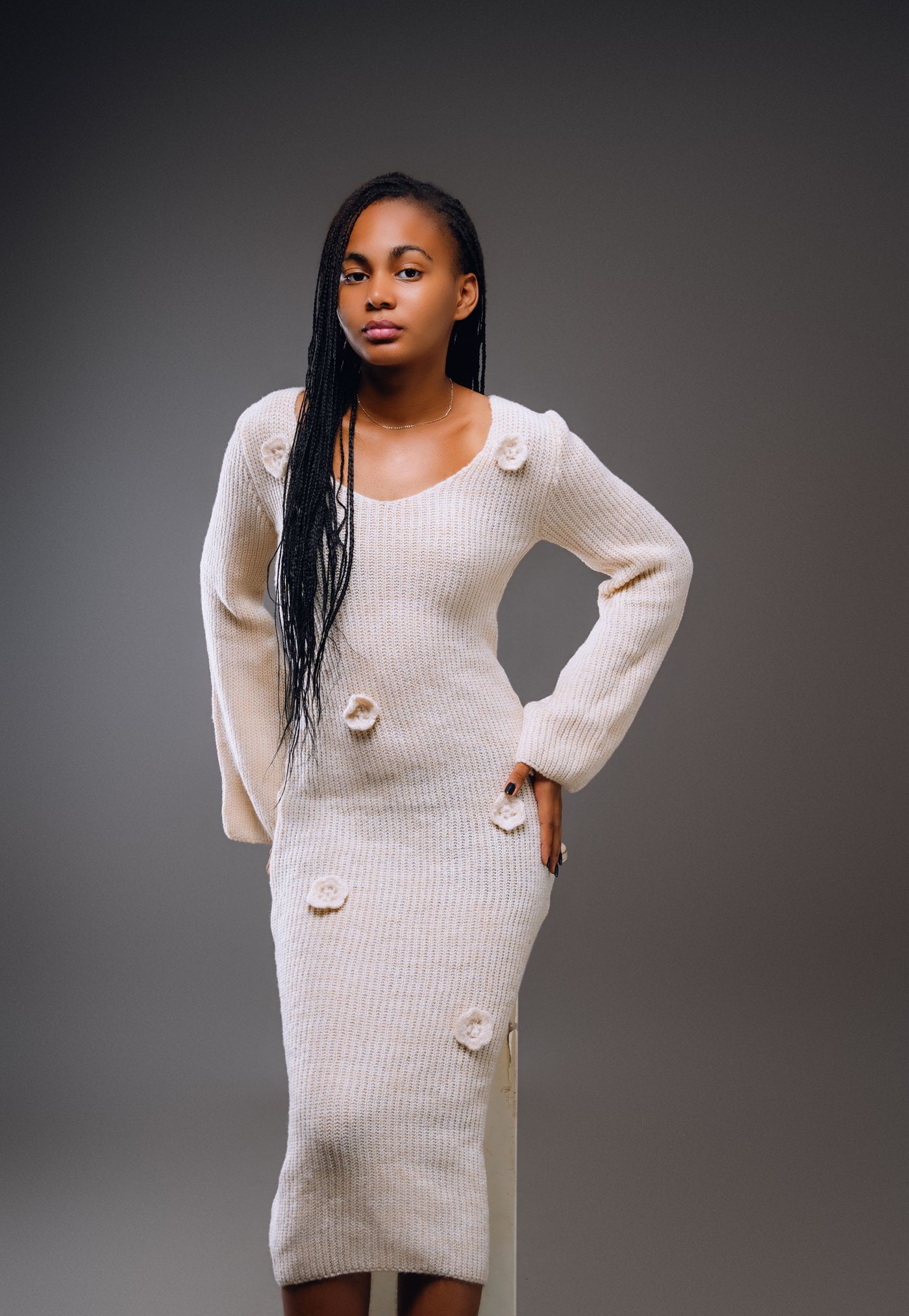 A cream knitted midi dress with long sleeves.