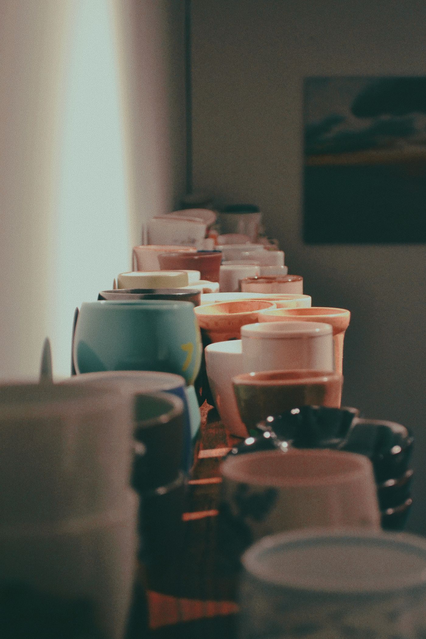 A collection of ceramic mugs arranged along a shelf.