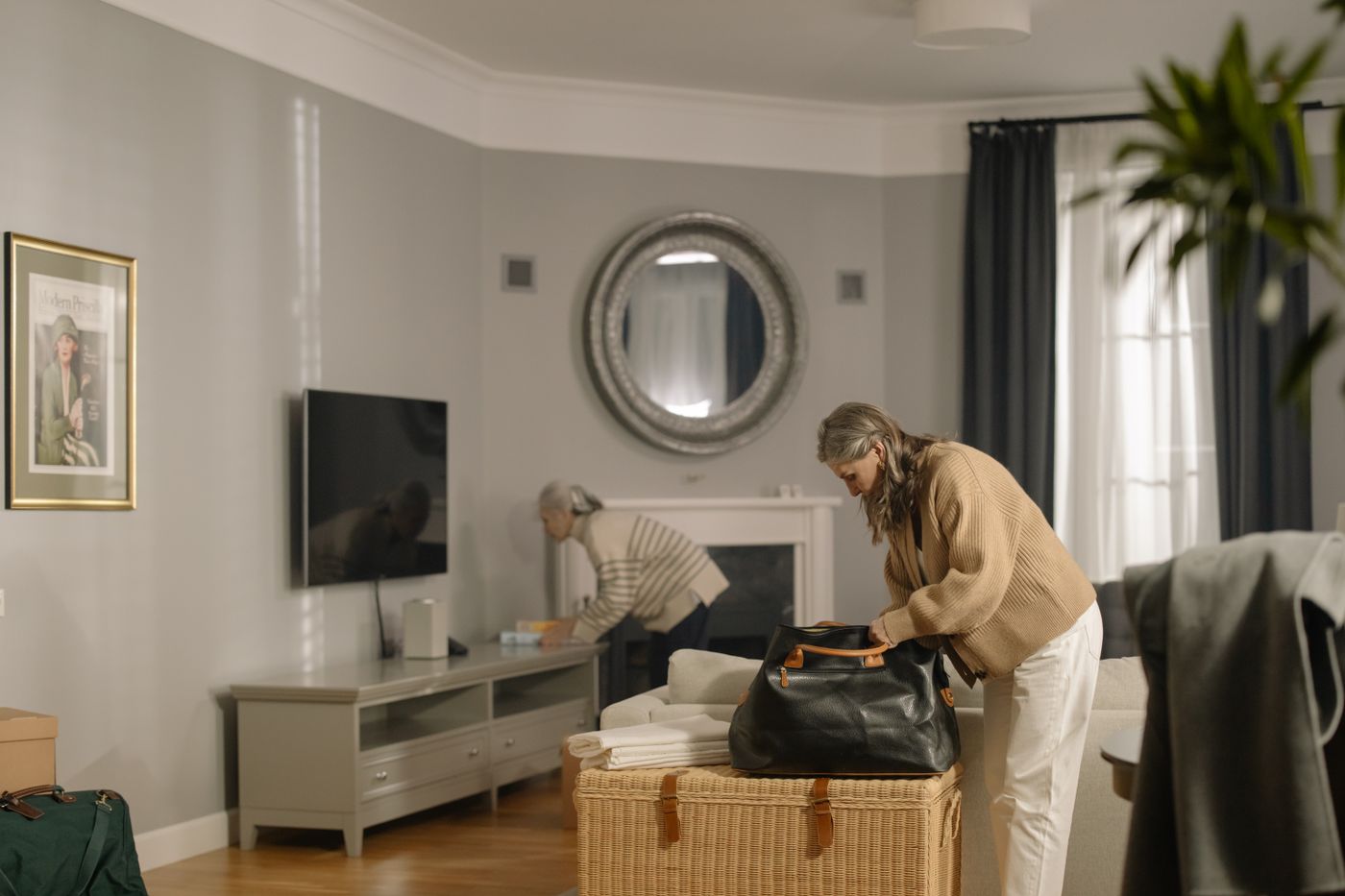 A woman packing a compact overnight bag at home.