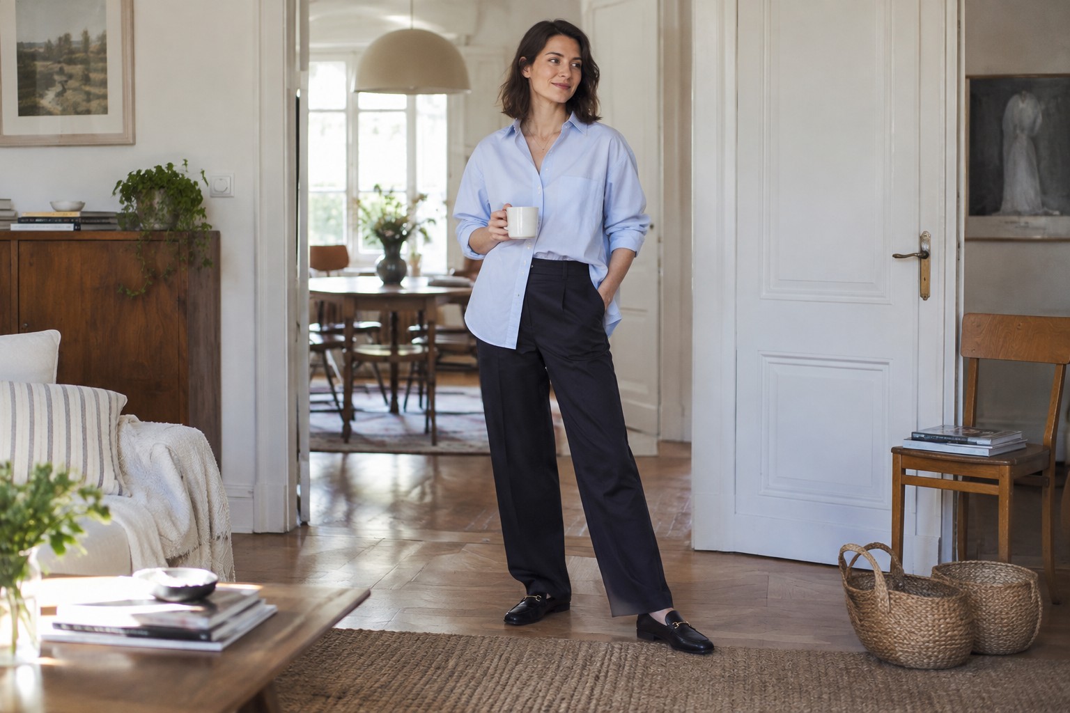 An oversized blue shirt partly tucked into dark trousers.