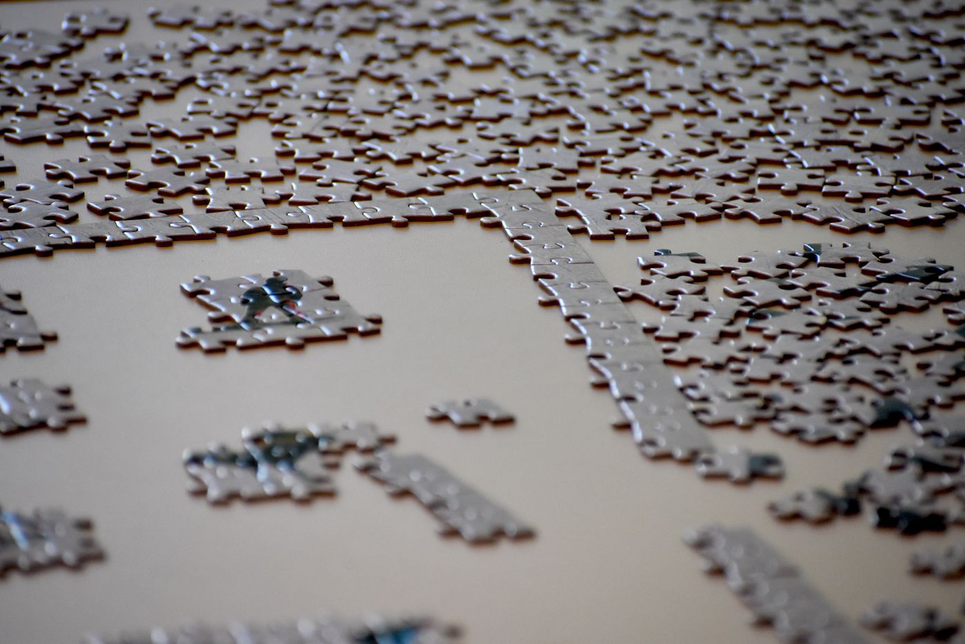 An unfinished jigsaw puzzle with loose pieces arranged on a table.