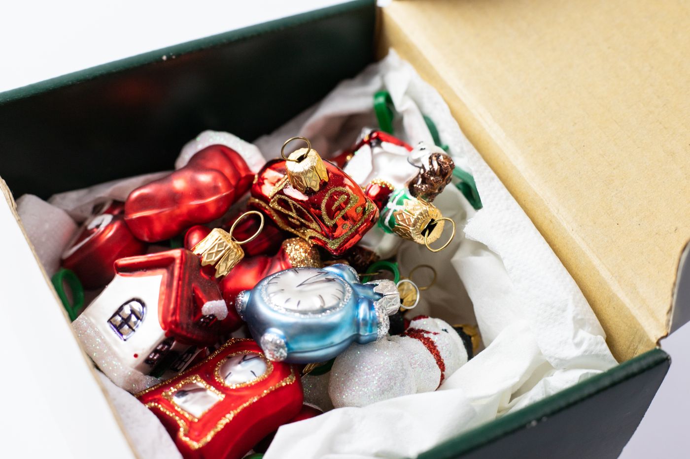 Seasonal ornaments packed in tissue inside a storage box.