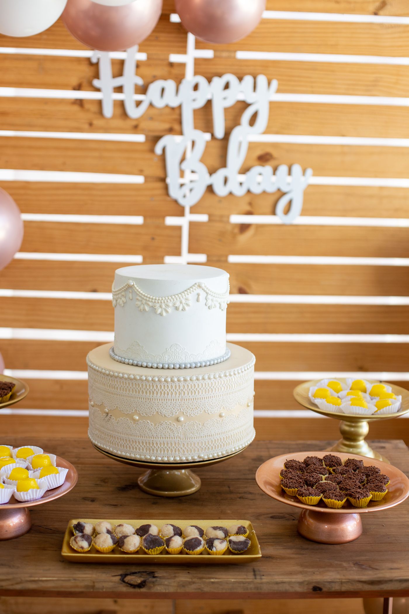 A birthday cake and small plates of sweets on a decorated table.