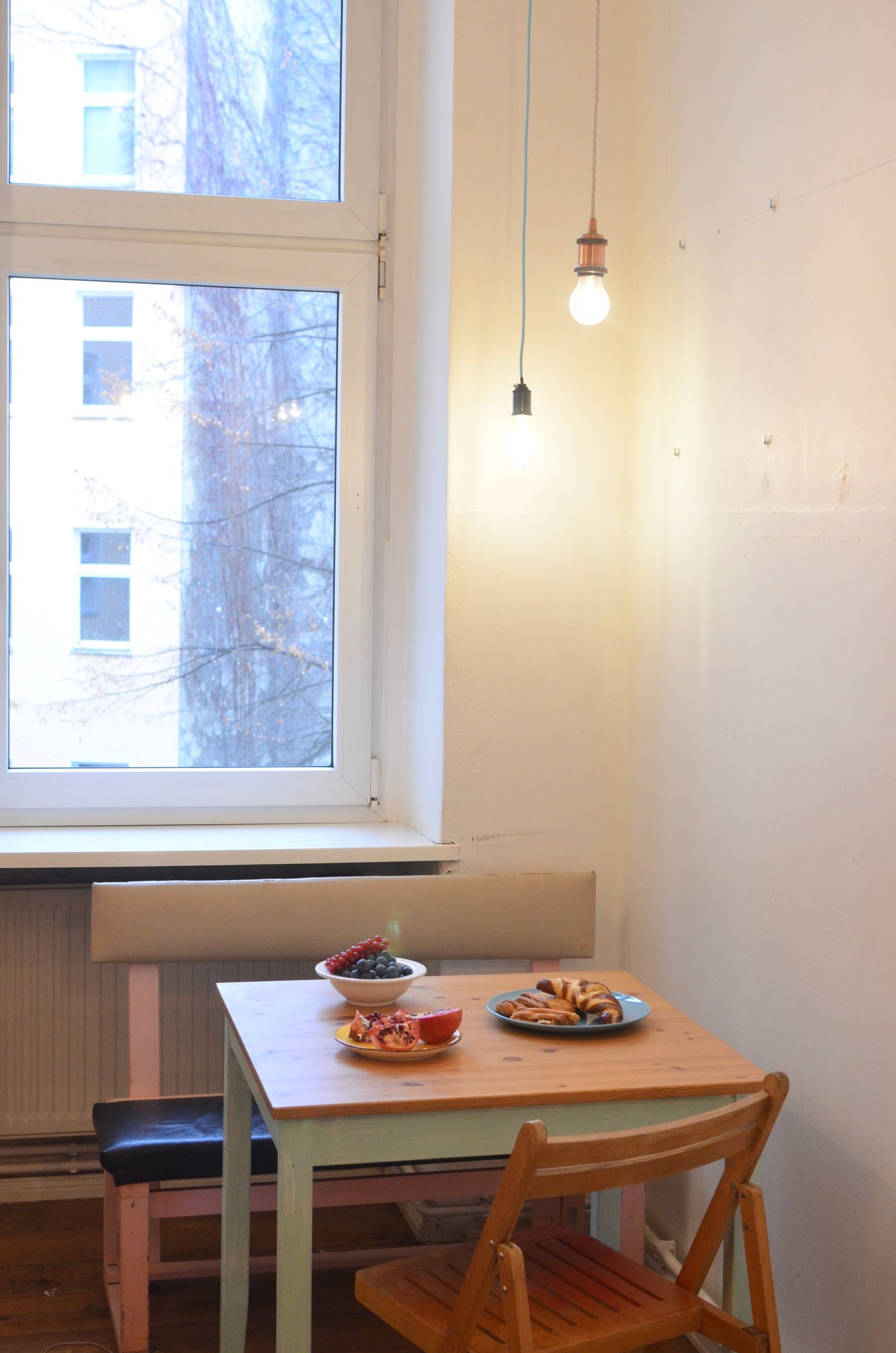 A compact wooden dining table set beside a window.