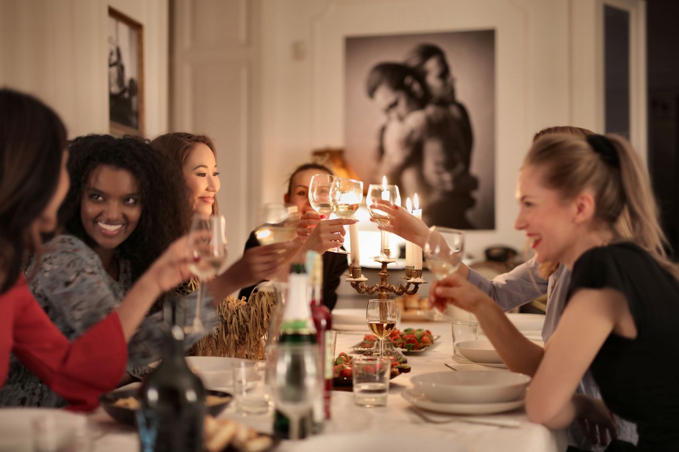 Friends sharing a candlelit dinner around a table.