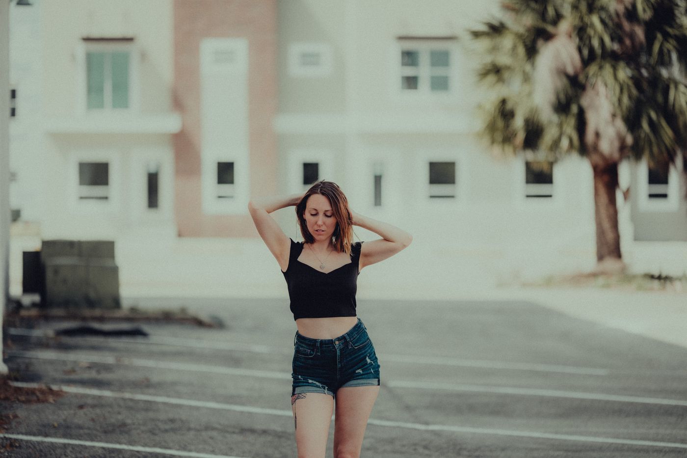 A woman wearing denim shorts and a dark top outdoors.