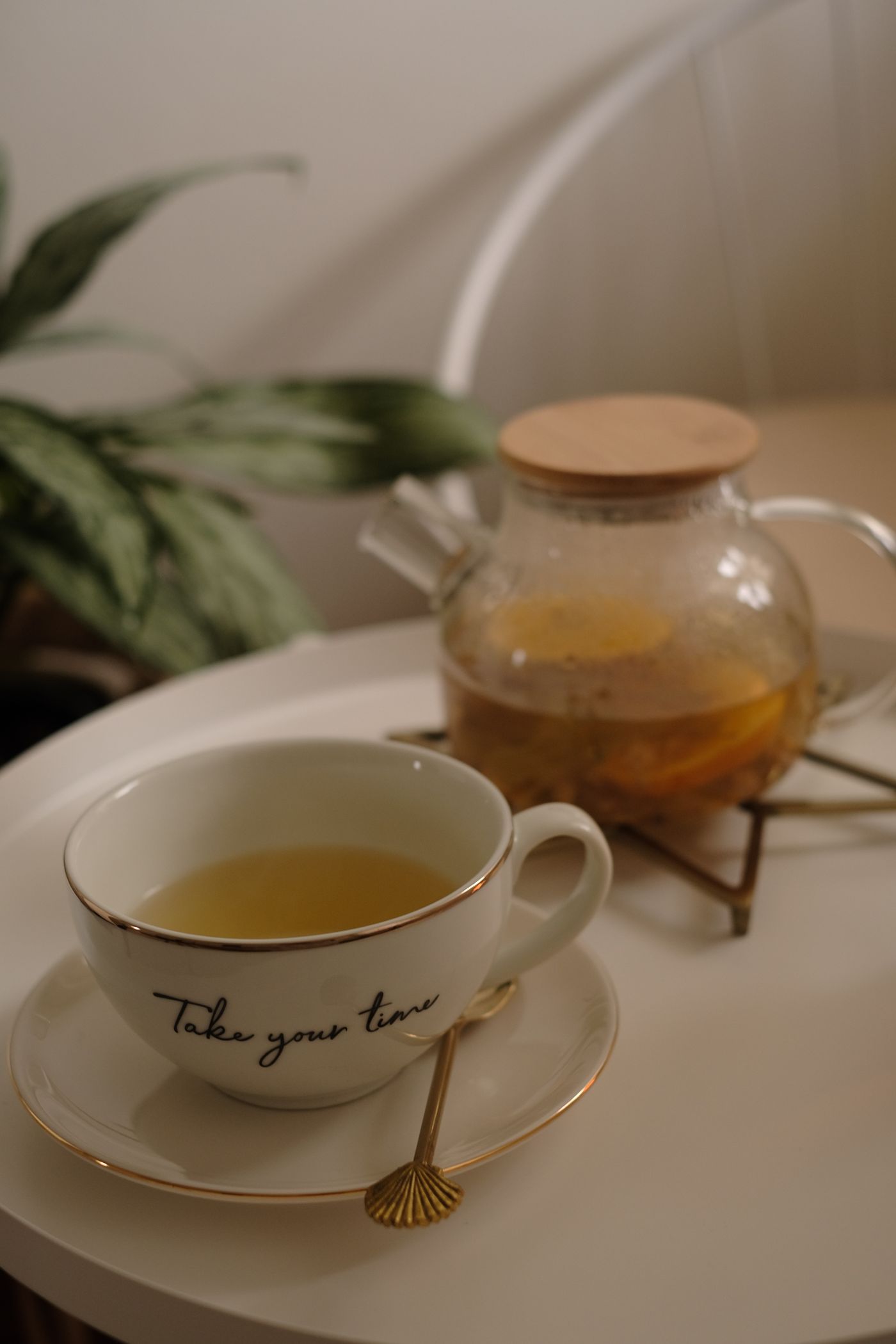 A teapot and cup of tea together on a white serving tray.