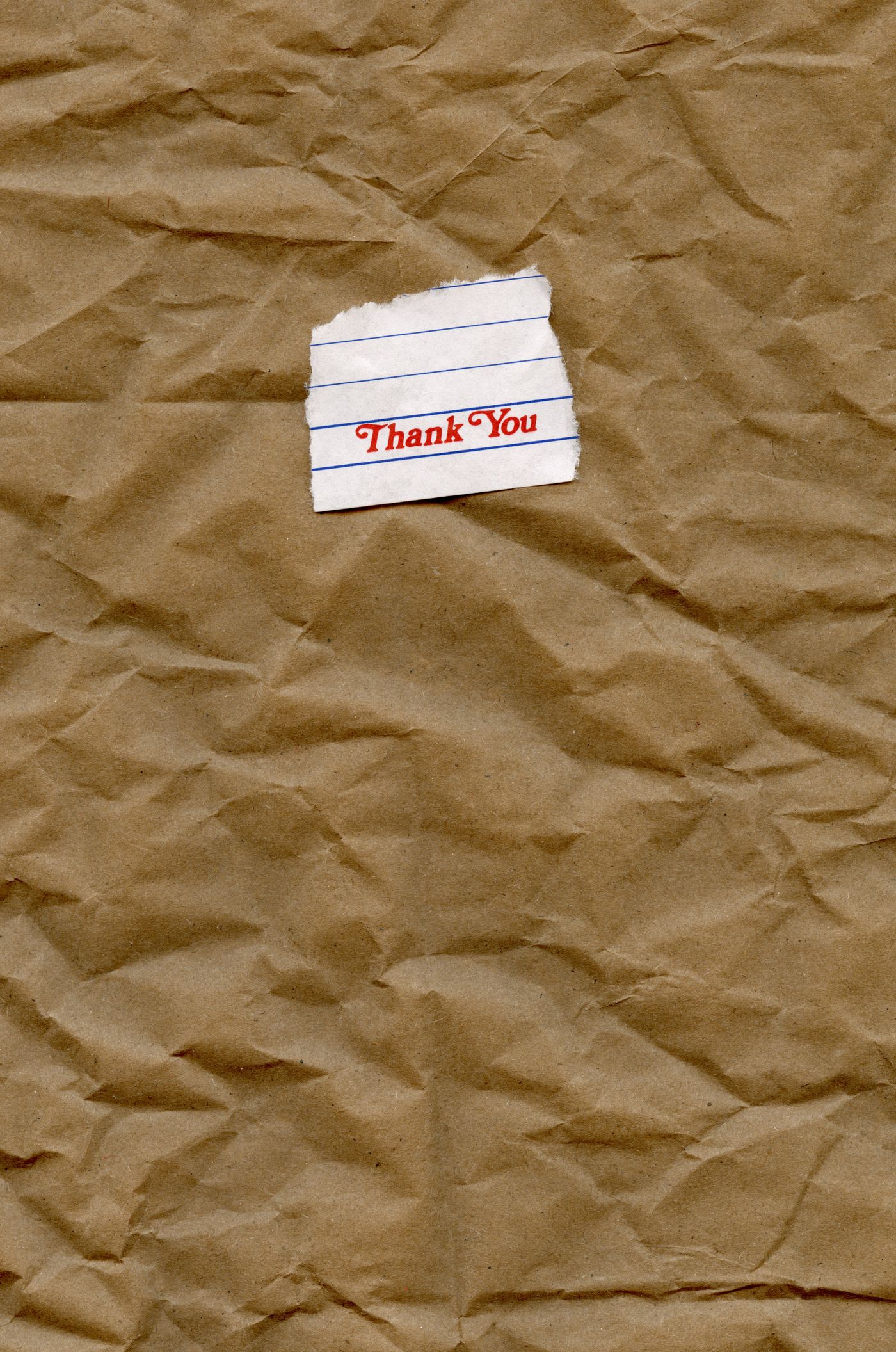 A small thank-you note resting on brown paper.
