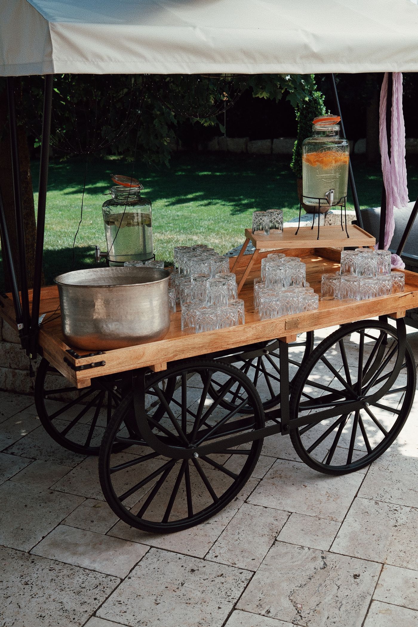 Water dispensers and drinking glasses arranged together on a cart.